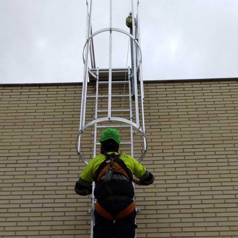 operario subiendo por la escalera de acceso