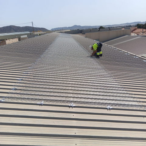 Protección de lucernarios en cubierta industrial con malla galvanizada