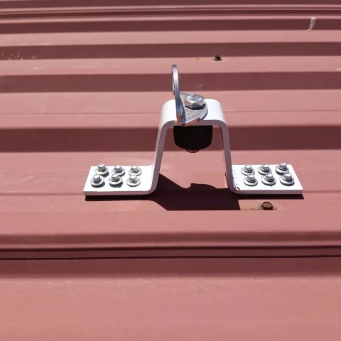 Punto de anclaje fijo certificado instalado en cubierta metálica para trabajos en altura.
